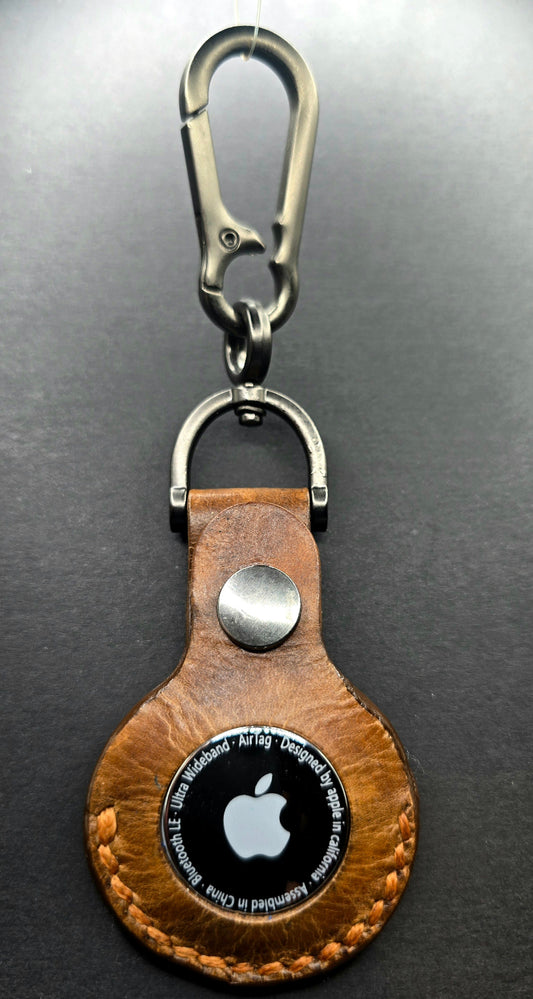 Brown Vegetable tanned leather Apple airtag case on a stainless steel keychain with airtag inserted.