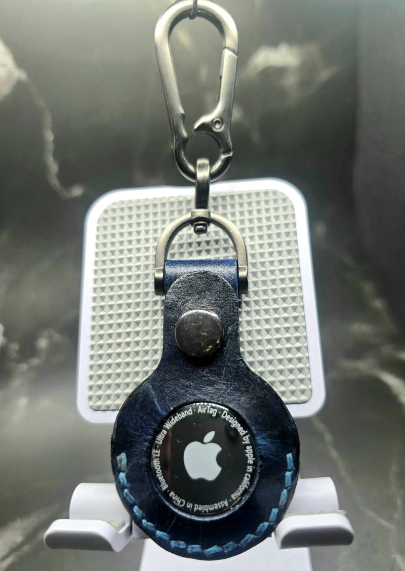Apple airtag case on a stainless steel keychain with airtag inserted.
