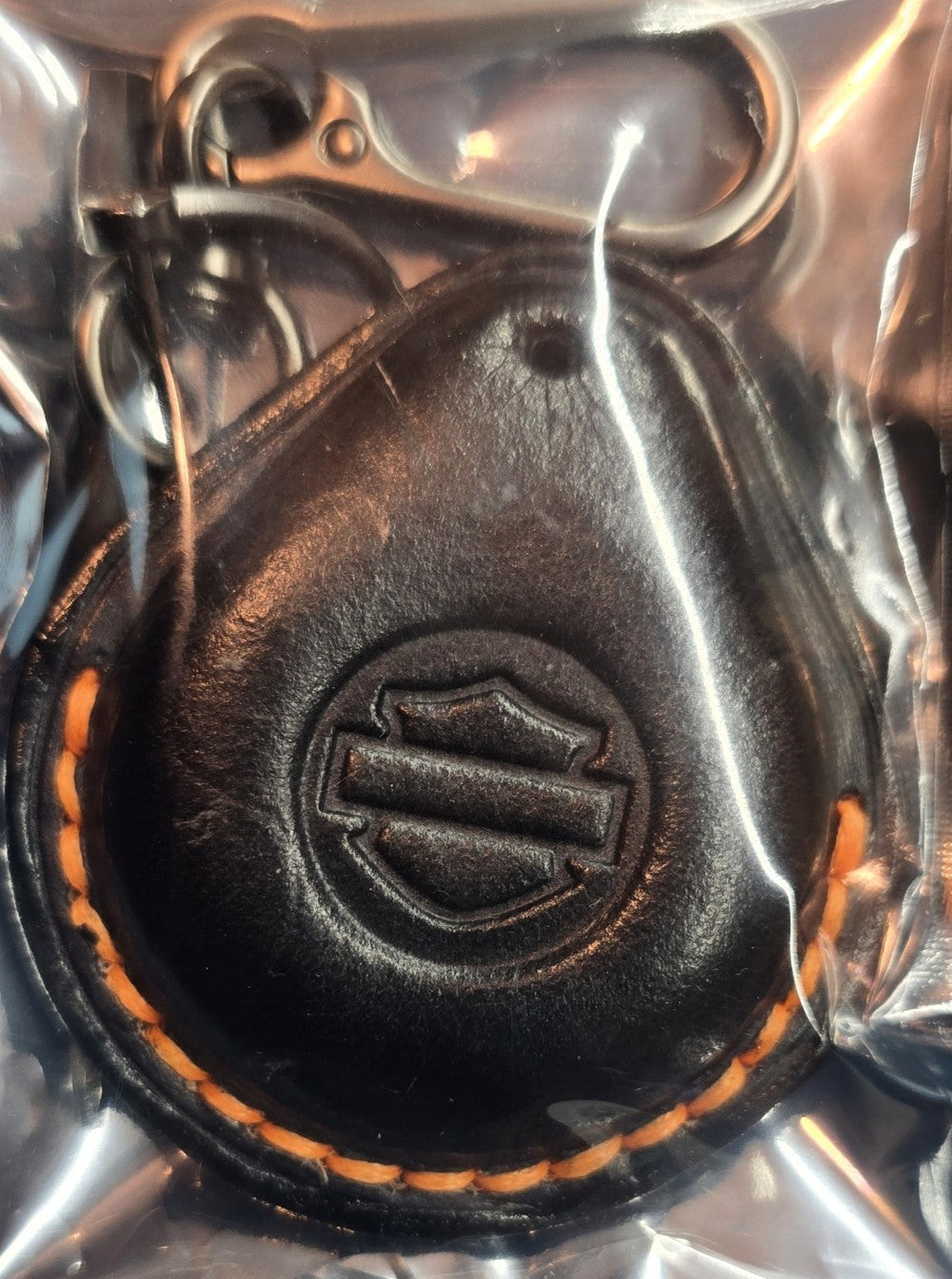 Black vegetable tanned leather key fob case for Harley Davidson motorcycles with orange stitching in packaging with included solid stainless steel Keychain and screwdriver.