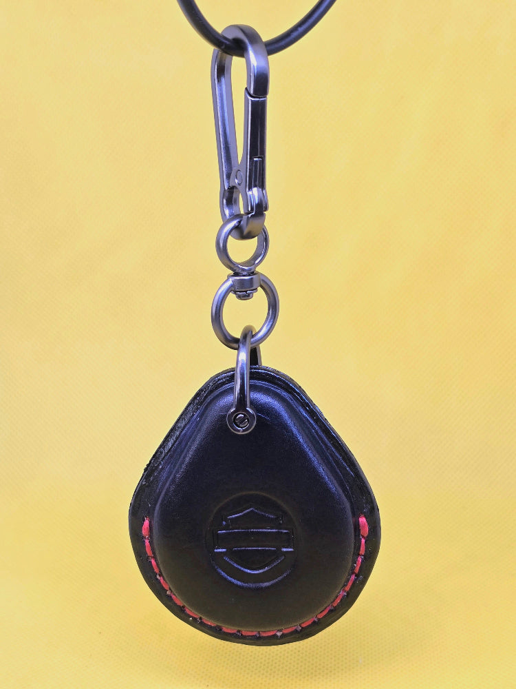 Black veg tan leather key fob case for Harley Davidson motorcycles with red stitching on a keychain.