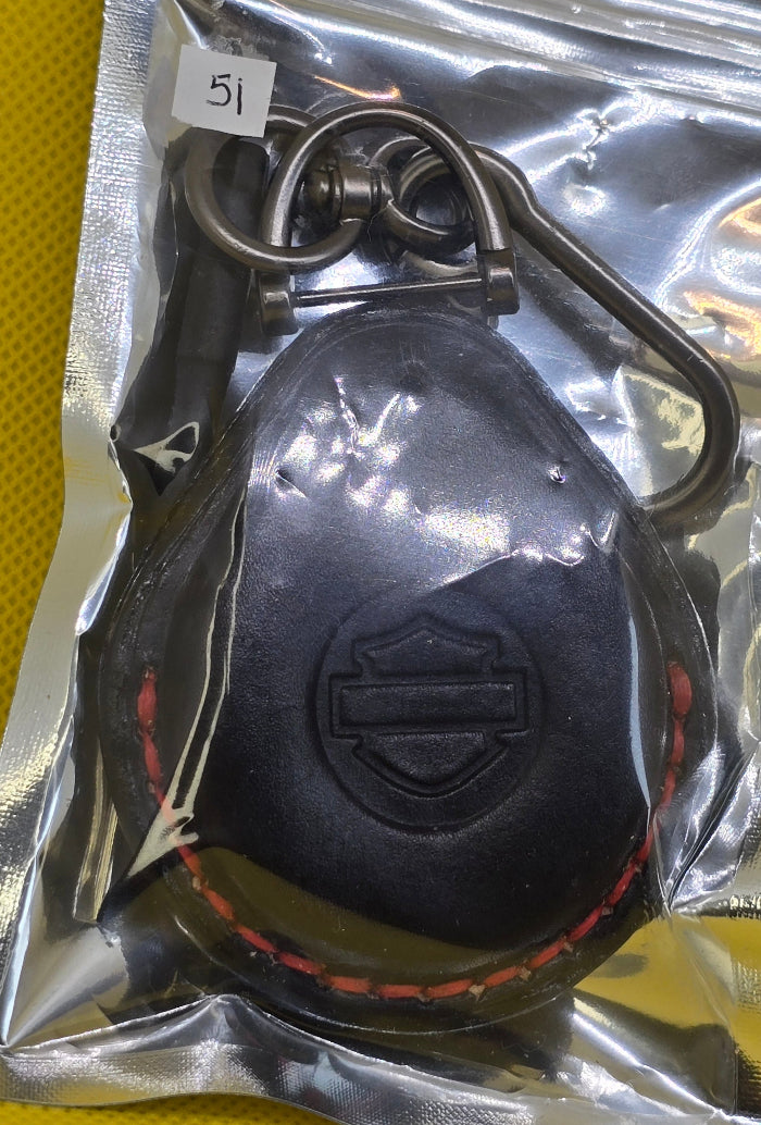 Black vegetable tanned leather key fob case for Harley Davidson motorcycles with red stitching in packaging with included Keychain and screwdriver.