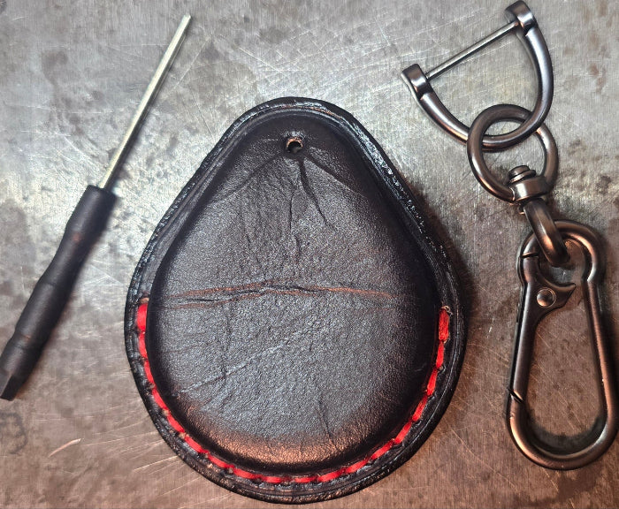 Back view of a Vegetable tanned leather key fob case for Harley Davidson motorcycles with red stitching with included stainless steel keychain and screwdriver.