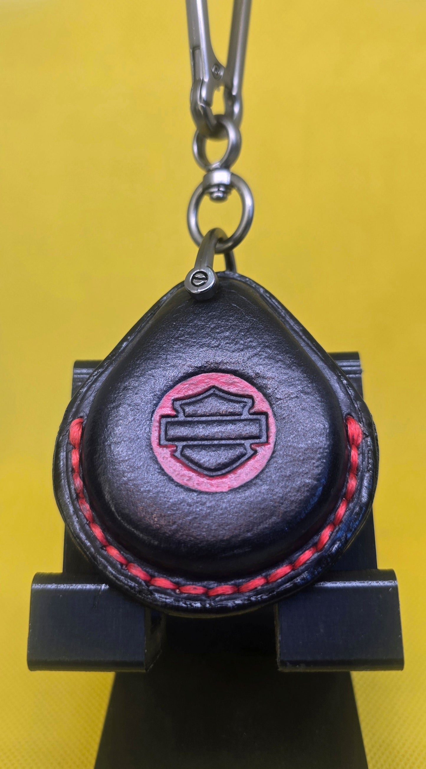 Black and red veg-tan leather key fob case for Harley Davidson motorcycles with red stitching on a lobster clasp keychain.
