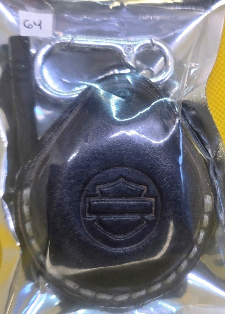 Gray vegetable tanned leather key fob case for Harley Davidson motorcycles in retail packaging with the included solid stainless steel lobster clasp keychain and mini screwdriver.