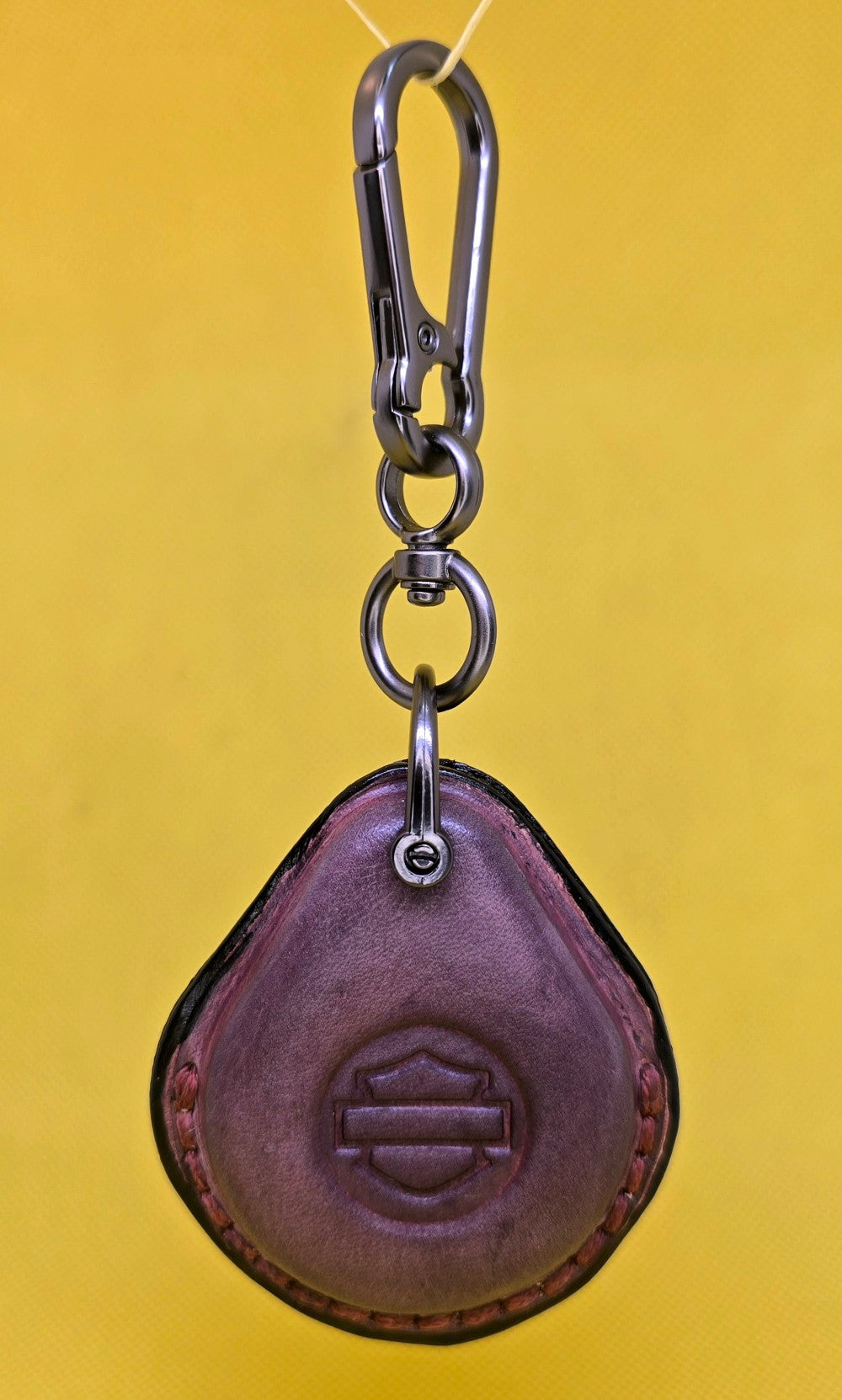 Mahogany veg-tan leather key fob case for Harley Davidson motorcycles hanging on a stainless steel lobster clasp keychain.