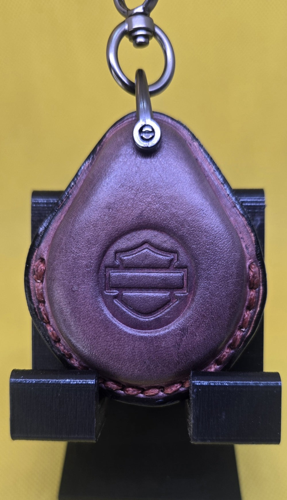 Mahogany colored vegetable tanned leather key fob case for Harley Davidson motorcycles hanging on a stainless steel lobster clasp keychain.