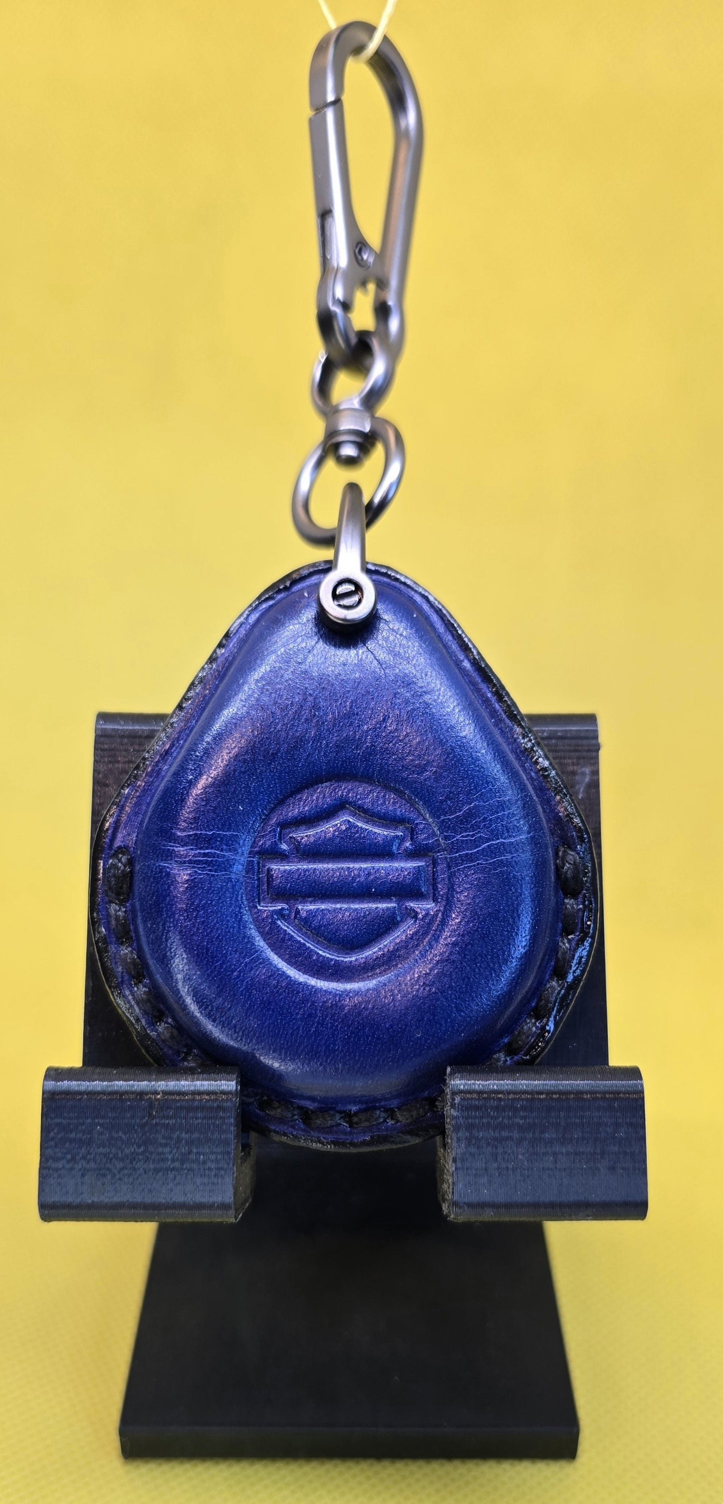 Navy blue colored vegetable tanned leather key fob case for Harley Davidson motorcycles hanging on a stainless steel lobster clasp keychain.