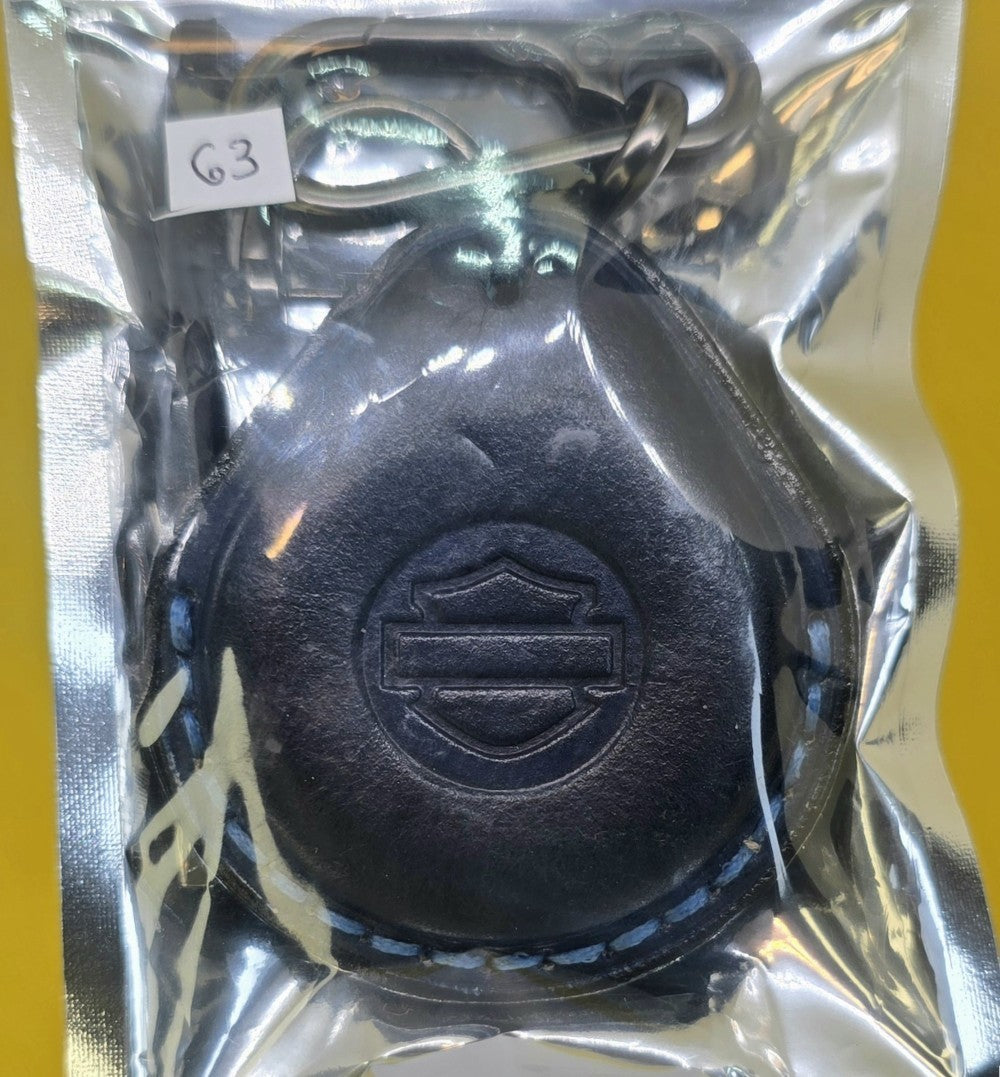 Navy blue vegetable tanned leather key fob case for Harley Davidson motorcycles in retail packaging with the included solid stainless steel lobster clasp keychain and mini screwdriver.