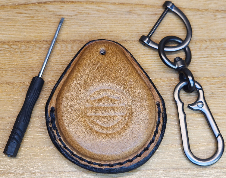 Light brown veg-tan leather key-fob case with black stitching for Harley Davidson motorcycles with a keychain and screwdriver.