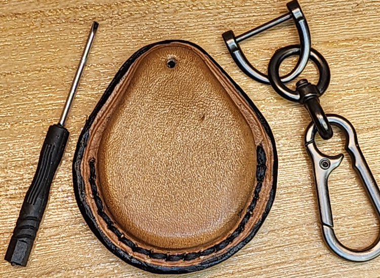 Back view of a brown/tan colored Veg-tan leather key fob case for Harley motorcycles with lobster clasp keychain and screwdriver.