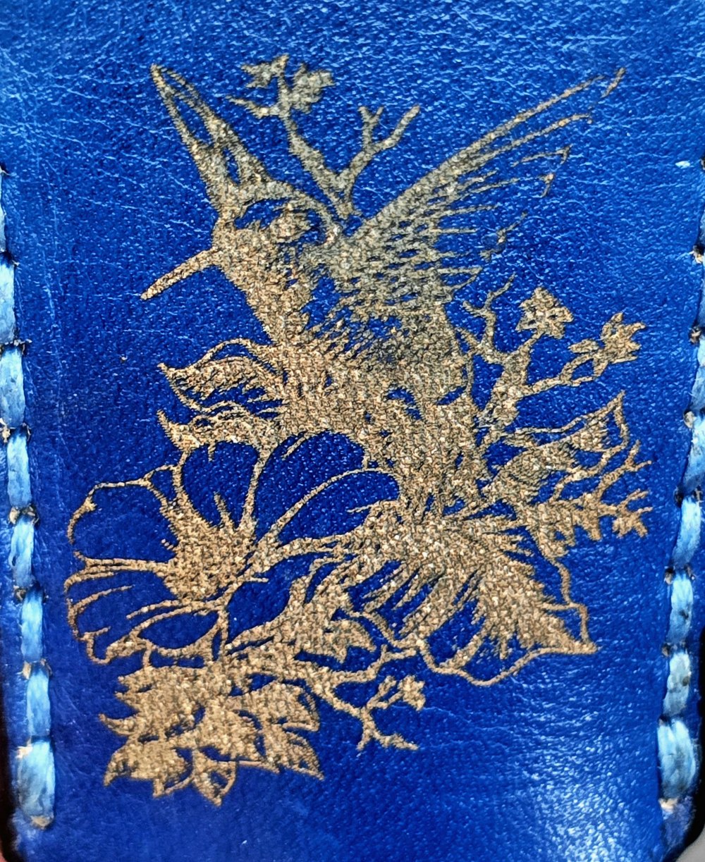 Navy blue veg-tan leather Bic lighter case with a hummingbird laser engraved into it.
