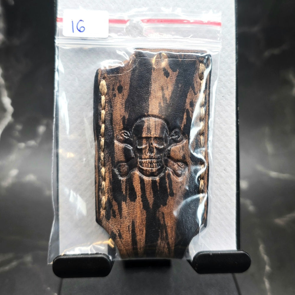 Black and brown camo-style veg-tan leather lighter case for bic lighters with a skull head stamped into it.
