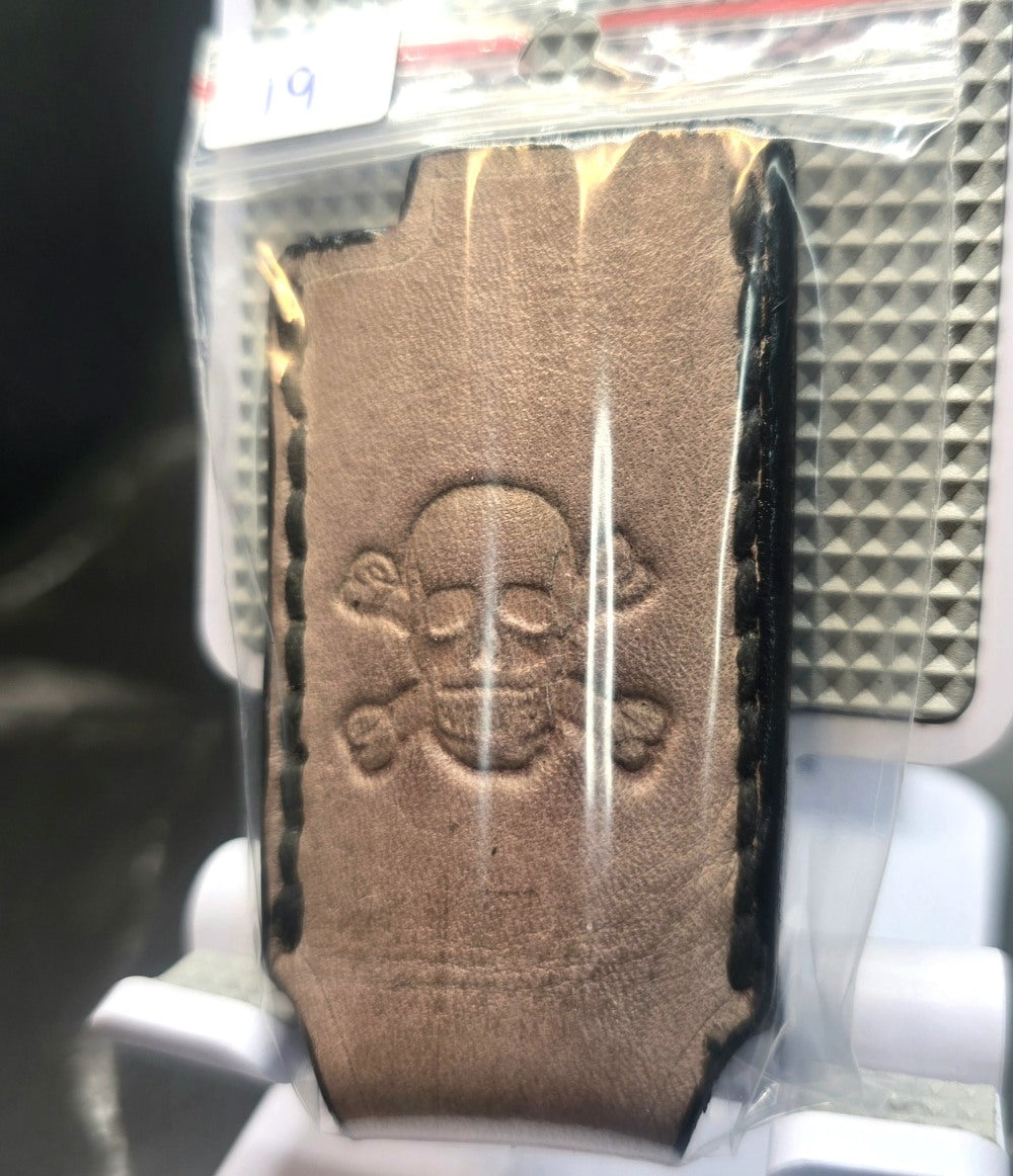 Light brown vegetable tanned leather Canadian Crafted lighter case for bic lighters with skull and crossbones stamped into it. Crafted in Canada by JnRcreativeCrafts.