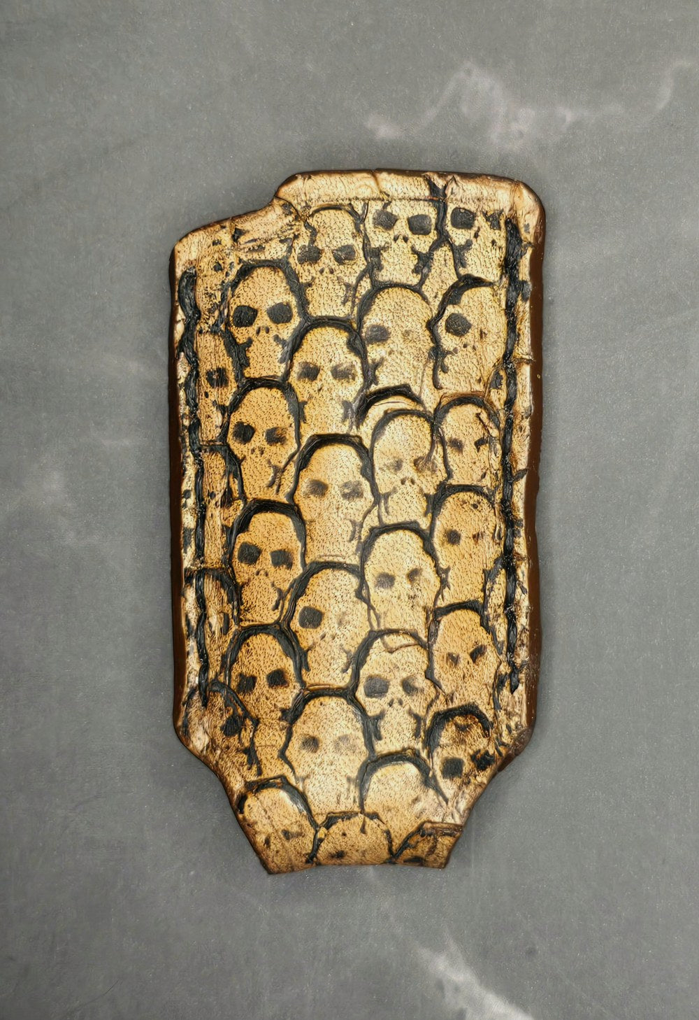 Light brown vegetable tanned leather lighter case for bic lighters with skulls stamped into it. Made in Canada.