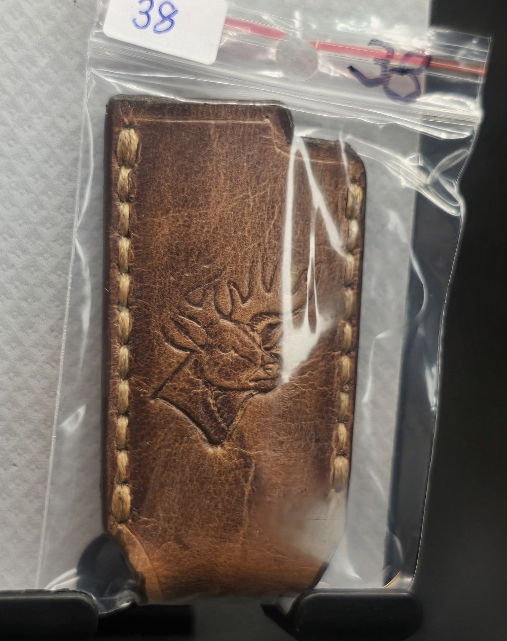Picture of a Canadian crafted veg-tan leather lighter case for bic lighters with a picture of a deer laser engraved into it in retail packaging.