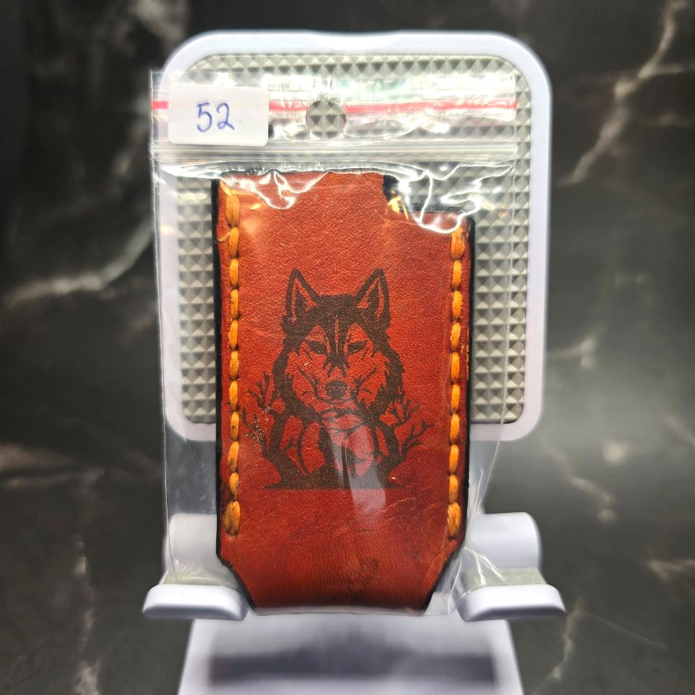 Picture of a Canadian crafted veg-tan leather lighter case for bic lighters with a picture of a wolf laser engraved into it.