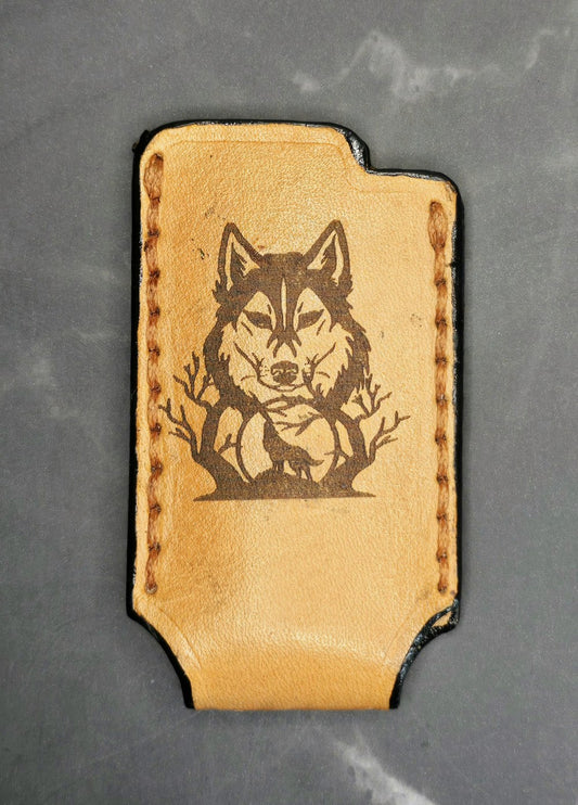 Light brown vegetable tanned leather lighter case for bic lighters with a wolf laser engraved on it.