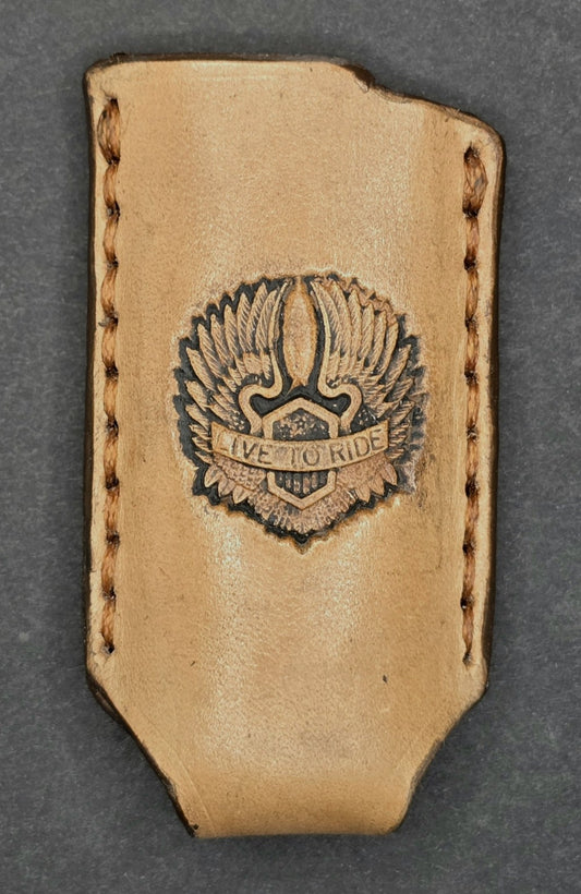Picture of a veg-tan leather bic lighter case with a "Live to Ride" stamped into it with wings.