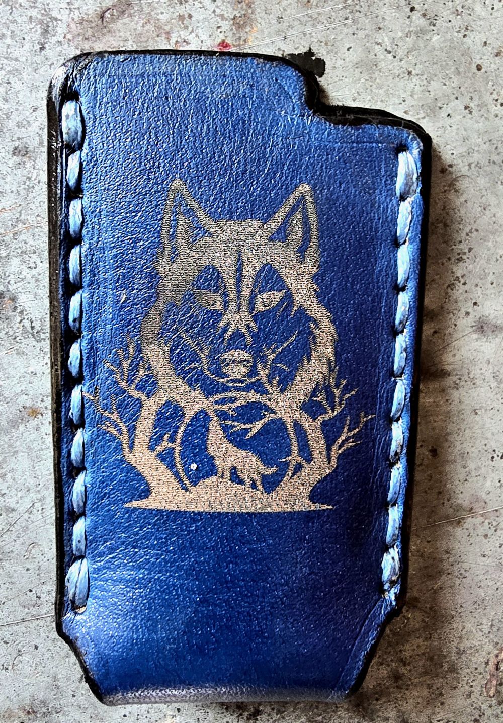 Navy blue veg-tan leather Bic lighter case with a wolf laser engraved into it. Handcrafted in Canada by JnRcreativeCrafts.