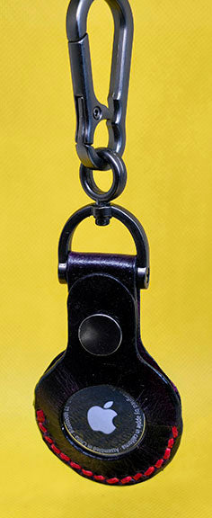Black full grain leather apple airtag case with red stitching and keychain.