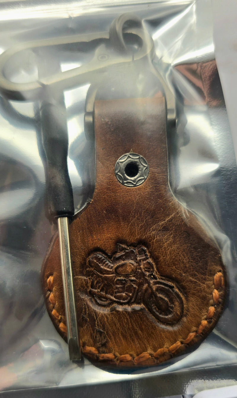 veg-tan leather apple airtag case with a motorcycle stamped into it on a stainless steel keychain in a bag with included screwdriver.