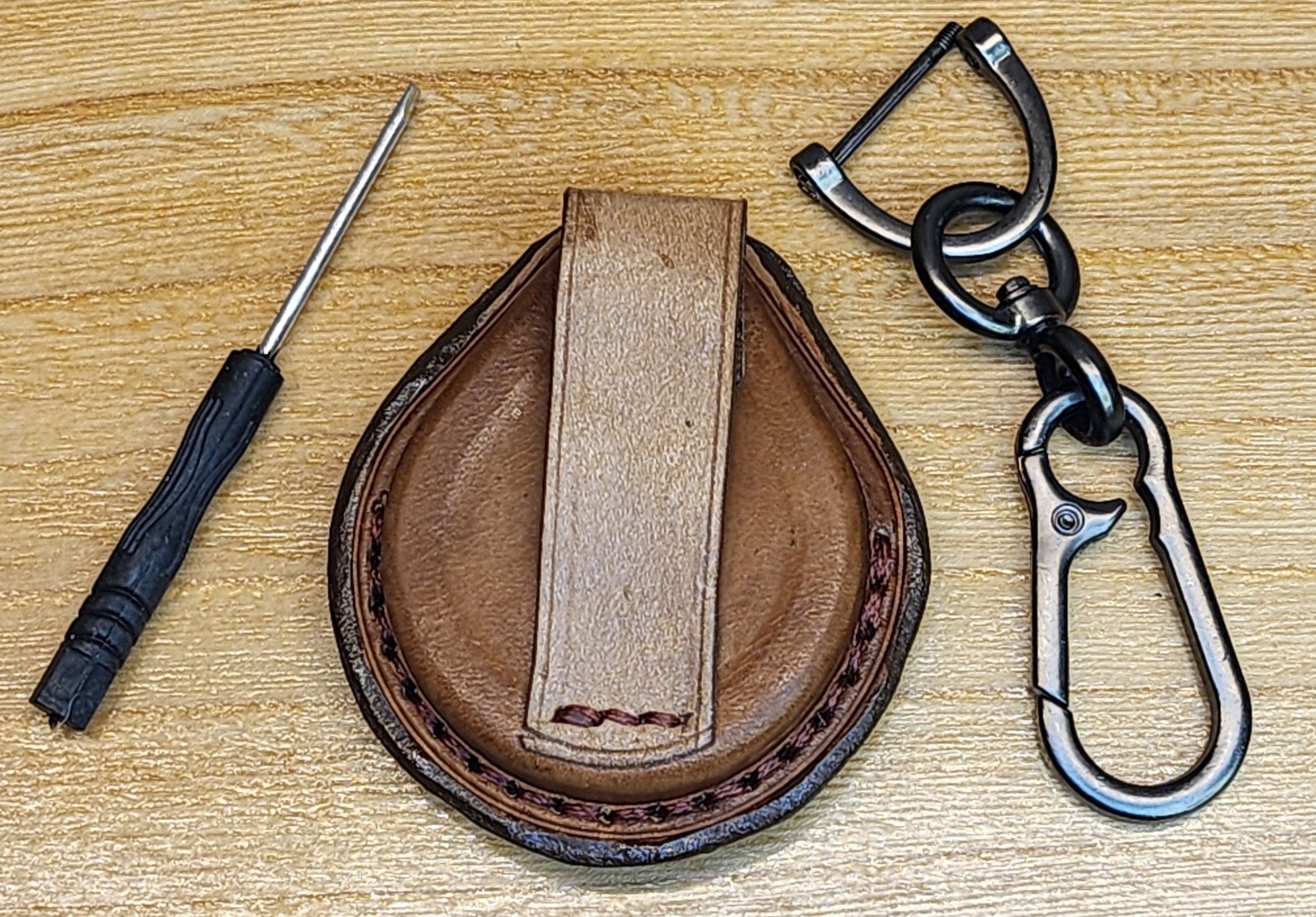 Back view of a brown leather Harley Davidson key fob case with belt loop, mini screwdriver and keychain