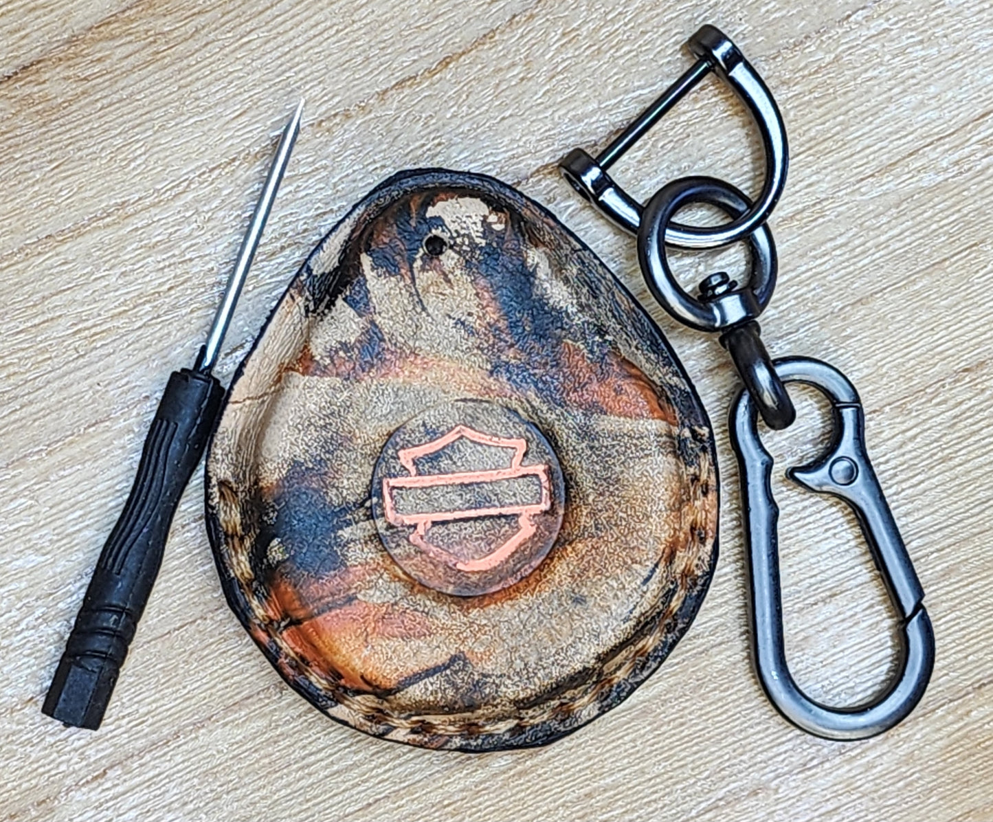 Front view of leather key fob case for Harley Davidson motorcycles in camo style orange and black. Étui porte-clés pour Moto Harley Davidson