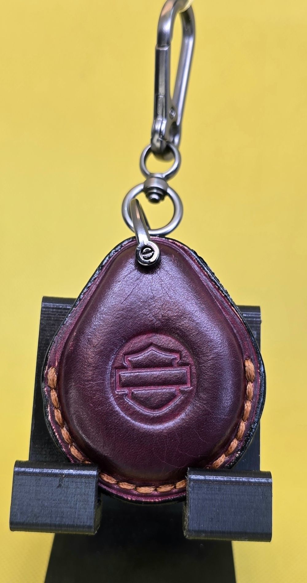 Burgundy veg-tan leather key fob case for Harley Davidson motorcycles hanging on a stainless steel lobster clasp keychain.