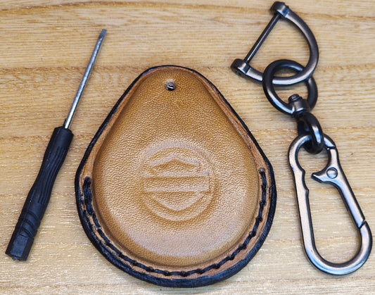 Light brown veg-tan leather key-fob case with black stitching for Harley Davidson motorcycles with a keychain and screwdriver. 