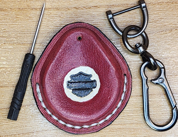 Front view of a red vegetable tanned leather Harley Davidson key fob case with keychain and mini screwdriver.