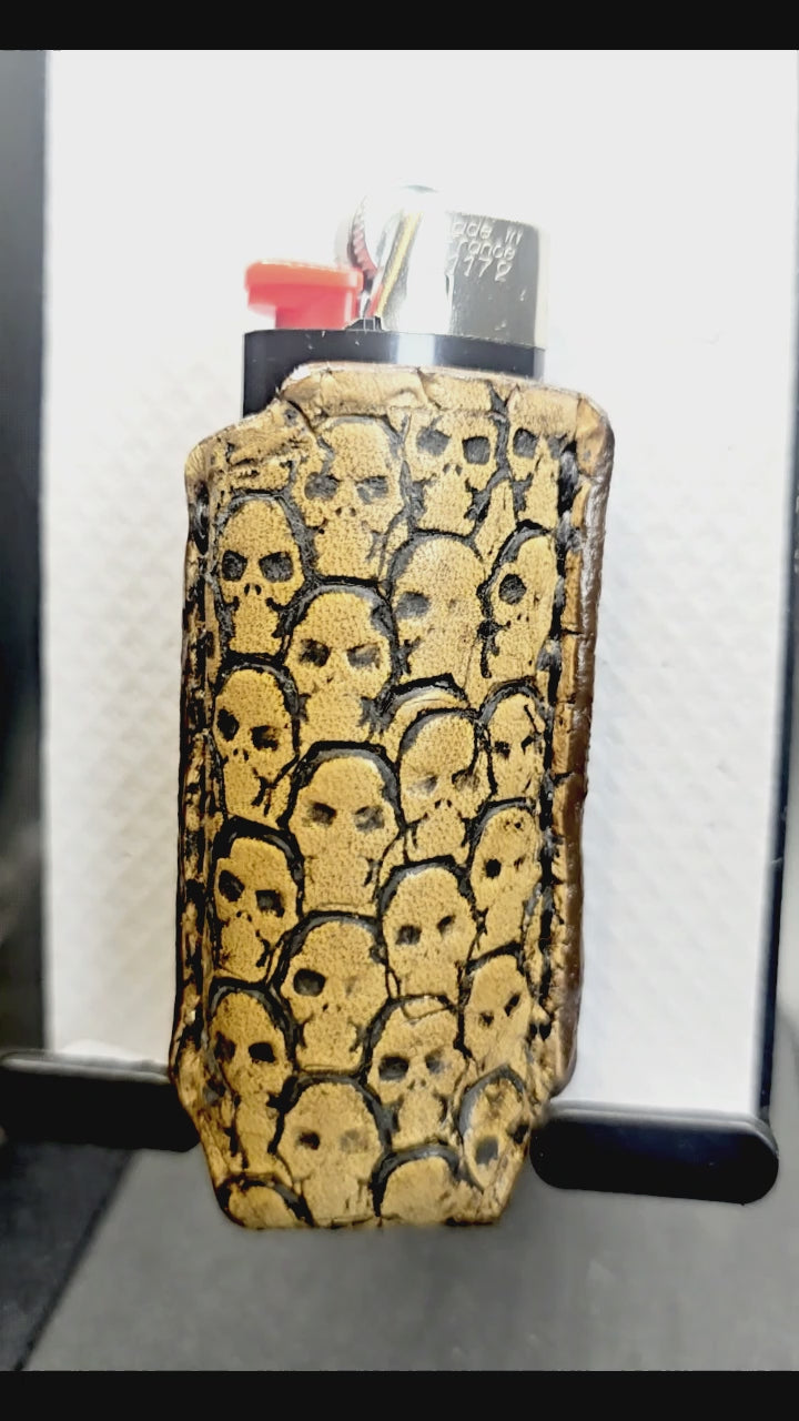 Video of a light brown vegetable tanned leather lighter case for bic lighters with skulls stamped into it. Proudly made in Canada.