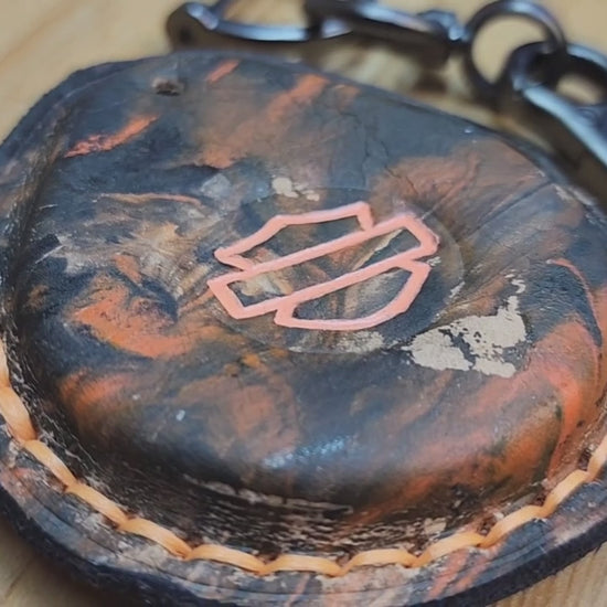 Video of a camo style black and orange leather Harley Davidson key fob case with keychain and screwdriver. Démonstration vidéo montrant un porte-clés Harley Davidson inséré dans un étui en cuir pour porte-clés.