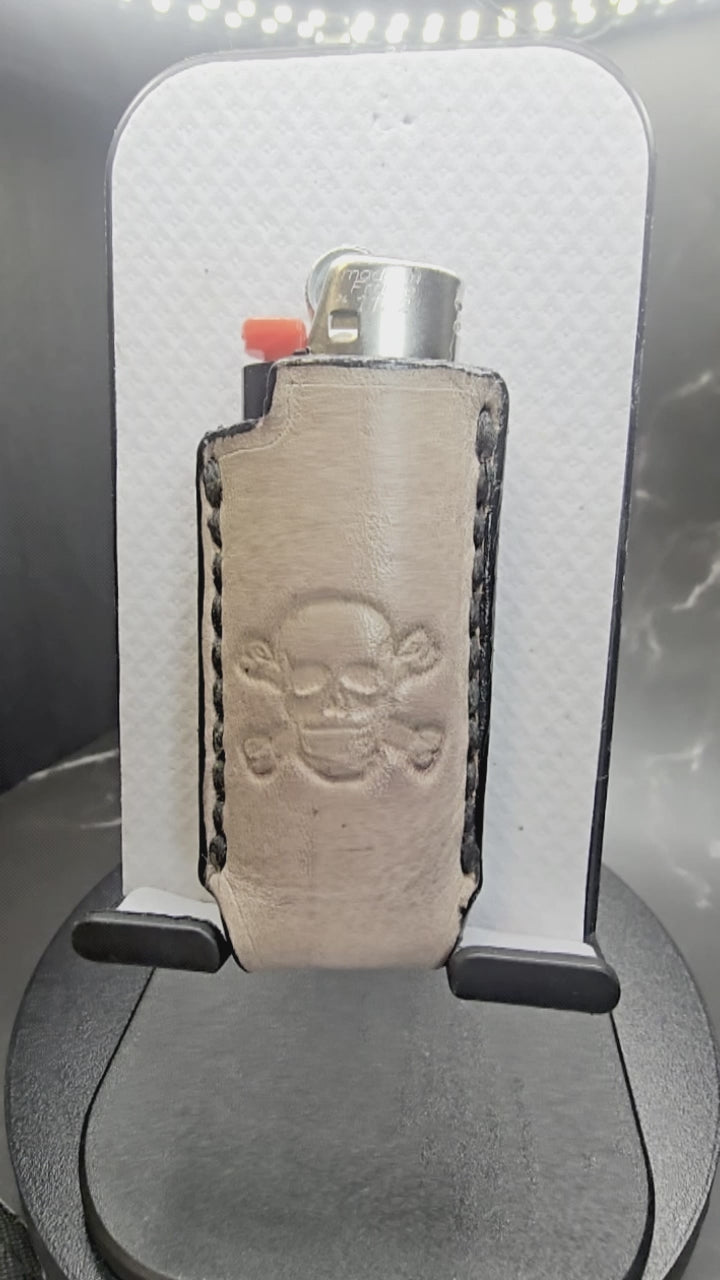 Video of a light brown vegetable tanned leather lighter case for bic lighters with skull and crossbones stamped into it. Crafted in Canada by JnRcreativeCrafts.