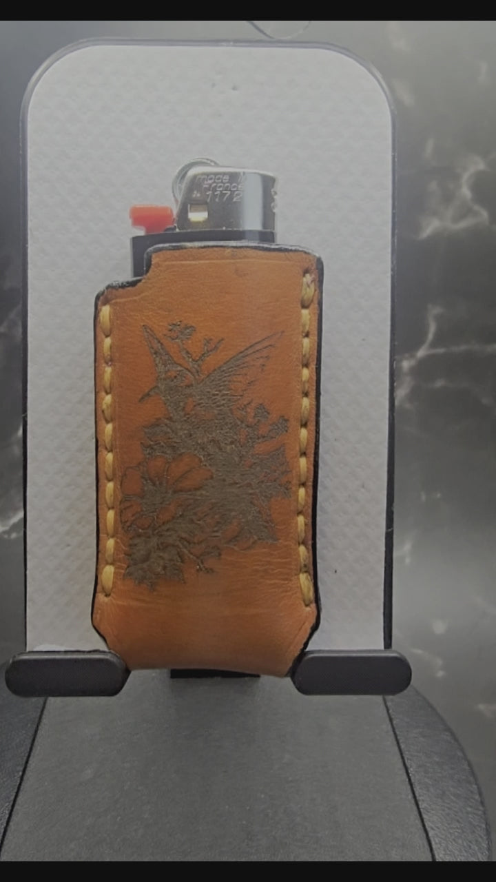 Video of a Canadian crafted veg-tan leather lighter case for bic lighters with a hummingbird on one side and a wolf on the other. Canadian made.