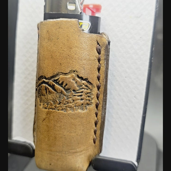 Video of a Veg-tan leather lighter case for bic lighters with a picture of mountains stamped into it.
