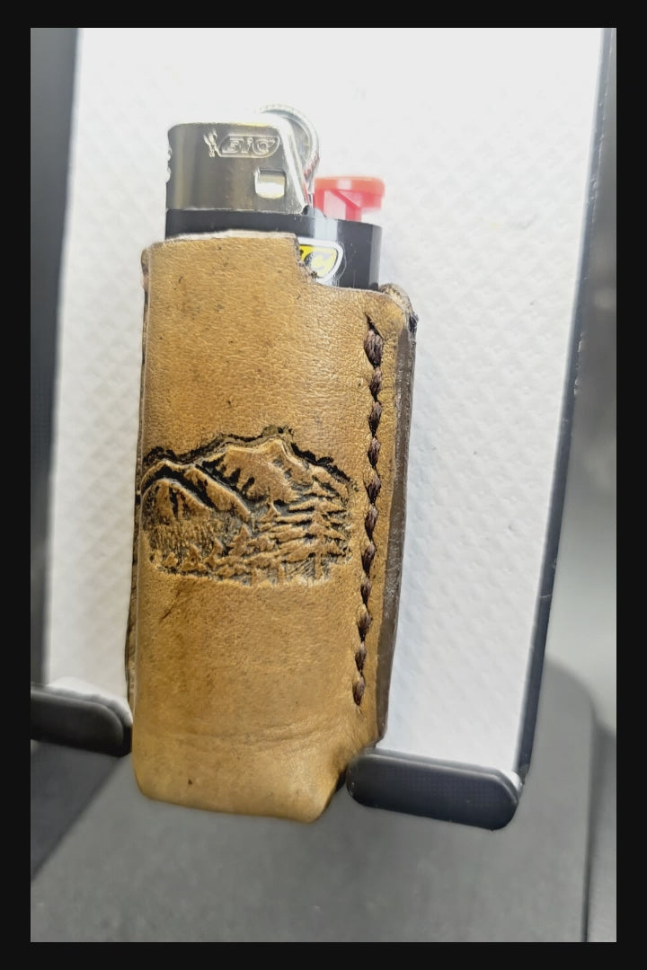 Video of a Veg-tan leather lighter case for bic lighters with a picture of mountains stamped into it.