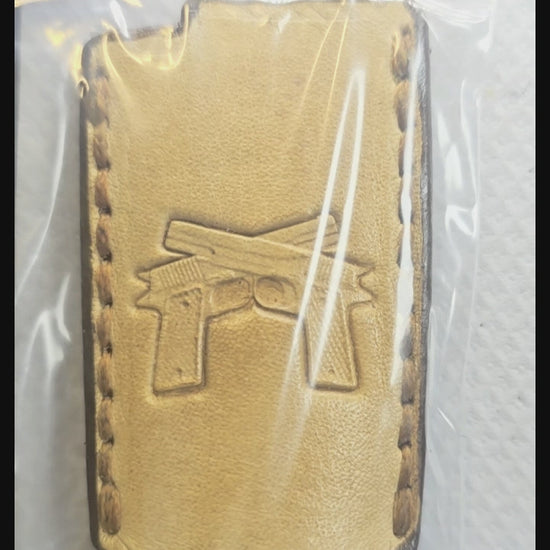 Video of a light brown veg-tan leather Bic lighter case with a pair of handguns stamped into it.