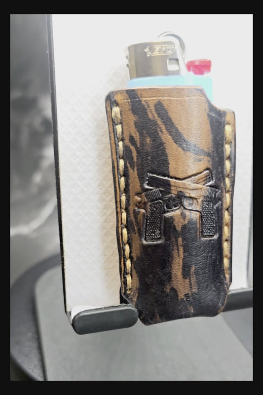Video of a black and brown camo-style veg-tan leather lighter case for bic lighters with a pair of handguns stamped into it.