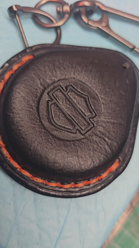 Video of a black Vegetable tanned leather key fob case for Harley Davidson motorcycles with orange stitching.