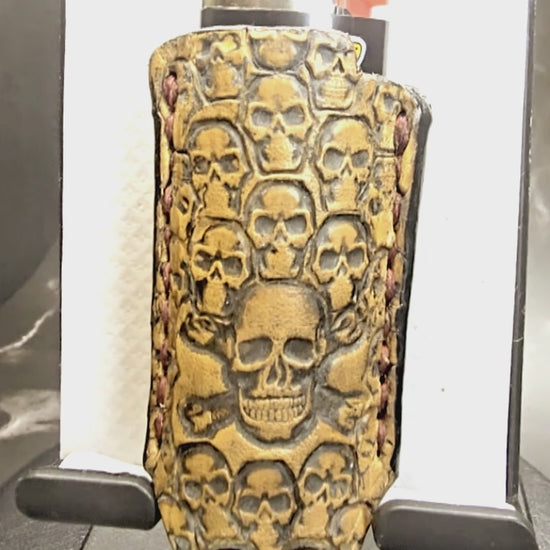Video of a light brown vegetable tanned leather lighter case for bic lighters with many skulls stamped into it. Crafted in Canada by JnRcreativeCrafts.