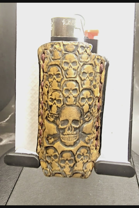 Video of a light brown vegetable tanned leather lighter case for bic lighters with many skulls stamped into it. Crafted in Canada by JnRcreativeCrafts.