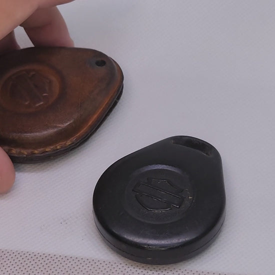 Demo showing Harley Davidson key fob being inserted into a leather case. Démonstration vidéo d'un porte-clés en cuir pour moto Harley Davidson.