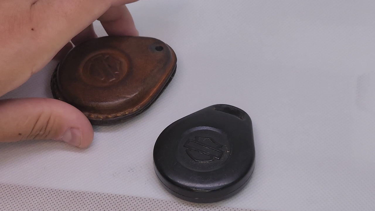 Demo showing Harley Davidson key fob being inserted into a leather case. Démonstration vidéo d'un porte-clés en cuir pour moto Harley Davidson.