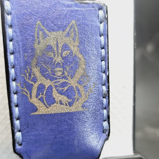 Video of a navy blue veg-tan leather Bic lighter case with a hummingbird laser engraved into it on one side and a wolf on the other created by JnRcreativeCrafts.
