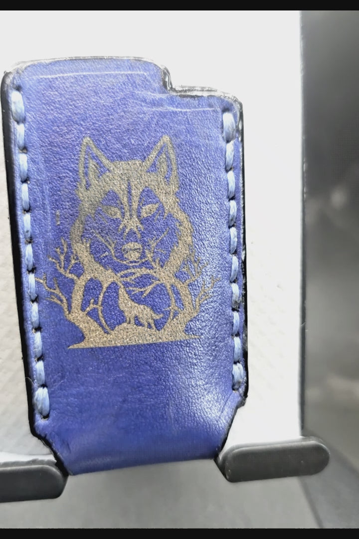 Video of a navy blue veg-tan leather Bic lighter case with a hummingbird laser engraved into it on one side and a wolf on the other created by JnRcreativeCrafts.