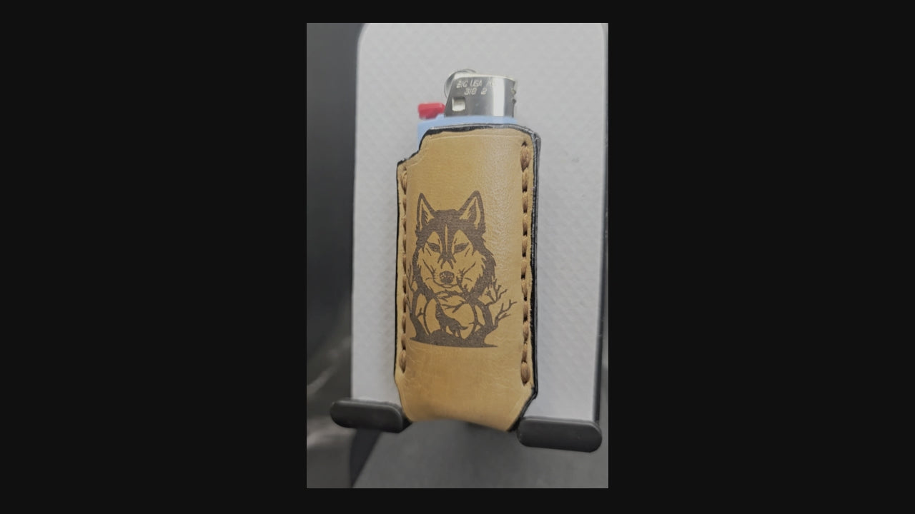 Video of a light brown veg-tan leather Bic lighter case with wolf laser engraved into it.