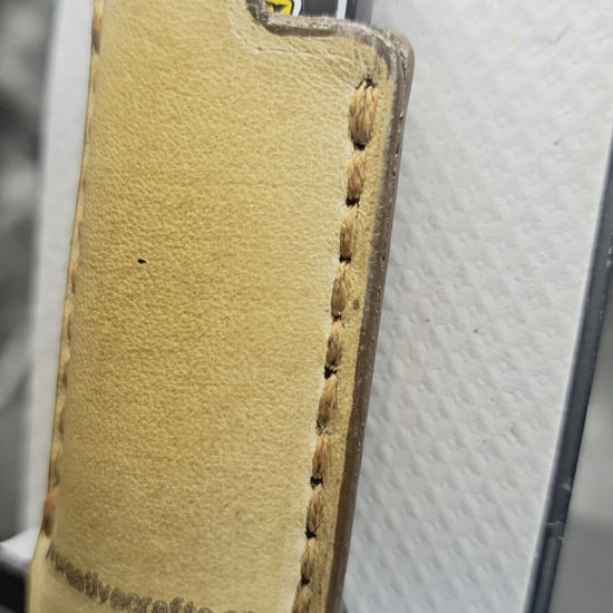 Video of a light brown vegetable tanned leather lighter case for bic lighters with skull and crossbones stamped into it. Crafted in Canada by JnRcreativeCrafts.