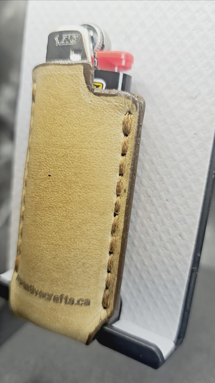 Video of a light brown vegetable tanned leather lighter case for bic lighters with skull and crossbones stamped into it. Crafted in Canada by JnRcreativeCrafts.