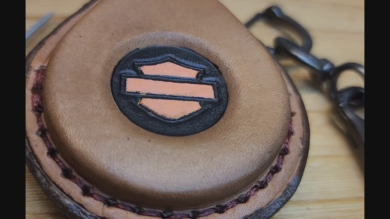 Video of a brown leather key fob case with orange Harley Davidson logo for Harley Davidson motorcycles